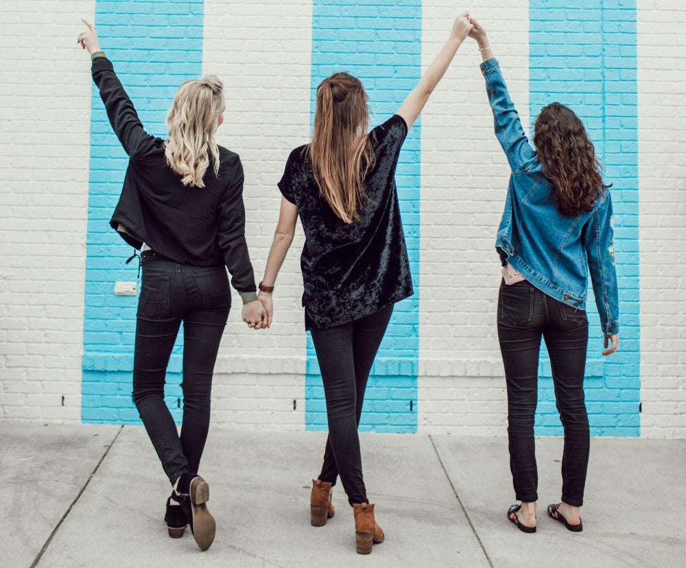 JULIE & ROSE - Affiliate - Aufnahme von hinten - drei Frauen halten sich an den Händen